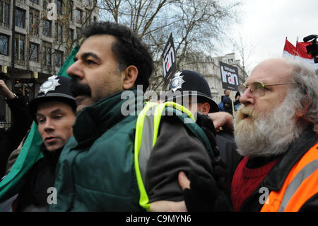 London, UK. 28.01.12. Ein Anti-Khomeini-Aktivist wird von der Masse durch Met Polizei und Stewards ausgeworfen, wie Hunderte der Kriegskoalition Demonstranten außerhalb der US-Botschaft in London zu stoppen. Stockfoto