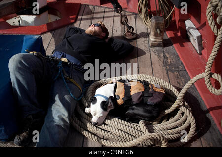 1. Dezember 2011 - Long Beach, Kalifornien, USA - MATTHEW GEMPLER, links, und Schiff Hund Pinne machen Sie eine Pause auf dem Deck der Lady Washington während einer Reise von Redondo Beach, Long Beach. Die hölzernen Windjammer ist eine Nachbildung des original Lady Washington, die in den späten als Handelsschiff gebaut wurde Stockfoto