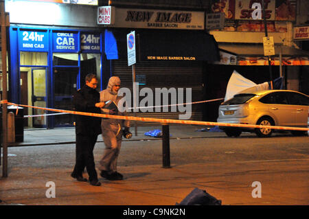 London, UK. 1. Februar 2012. Forensischen Teams untersuchen am Unfallort einen tödlichen Schüssen in Turnpike Lane, London. Die Verbrechen-Szene-Zelt ist hinter dem Fahrzeug im Hintergrund sichtbar. Stockfoto