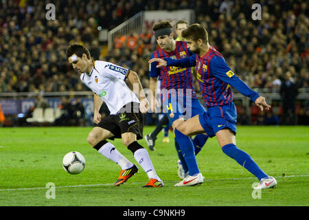 02.01.2011 - VALENCIA, Spanien / / COPA DEL REY - Fußball - Valencia CF vs FC Barcelona - 1/2 Finale - Estadio Mestalla---Aduriz von VAlencia CF versucht, den Ball vor Pique zu kontrollieren Stockfoto