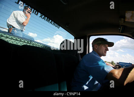 Bringen Sie 11. Juli 2007 - Dixon, Illinois, USA - Paul Burrs, 28, rechts, und Matt Schumacher, 28, alte Geräte auf einem Bauernhof Auktions-Website in der Nähe von Dixon, Illinois. Die beiden Männer bündeln ihre Kräfte vor zwei Jahren um Bauernhof Reihenkulturen und Viehzucht in der Nähe von Dixon, Illinois, zwei Stunden westlich von Chicago. (Bild Kredit: Stockfoto