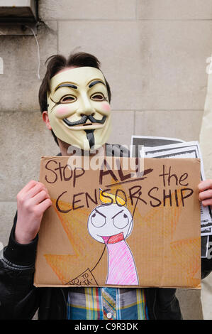 Mitglied aus der Hacker-Gruppe "Anonymous" mit einer "V for Vendetta" Maske hält eine hausgemachte Plakat Berufung, "die Zensur zu stoppen" Stockfoto