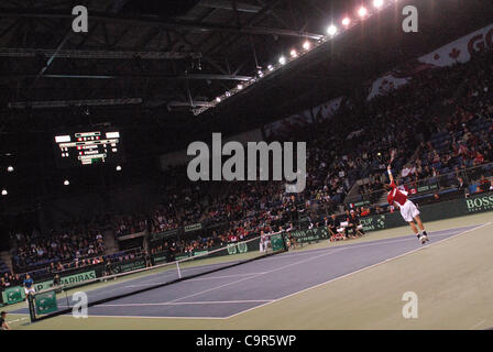 Kanadas Vasek Pospisil dient den Ball während des Spiels Davis Cup World Group Krawatte gegen Jo-Wilfried Tsonga Frankreichs am 10. Februar 2012 in Vancouver, Kanada. Der Franzose Kraft und Schnelligkeit bewiesen viel zu viel für eine erratische Pospisil, der kämpfte um seine dienen zu finden und verlor 6-1, 6-3, 6-3 in einer Stunde Stockfoto