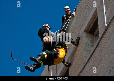 Feuerwehr Abseilen vom Dach der Schule bei den Rettungsarbeiten nach einem Erdbeben in einer landesweiten Übung Simulation an der Bet-Hakerem Grundschule. Jerusalem, Israel. 20. Februar 2012. Stockfoto