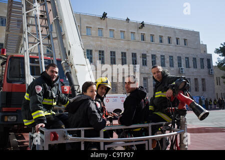 Feuerwehr Abseilen vom Dach der Schule und einen Kran zur Simulation von Rettungsaktionen nach einem Erdbeben in einer landesweiten Übung an der Grundschule von Bet-Hakerem verwenden. Jerusalem, Israel. 20. Februar 2012. Stockfoto