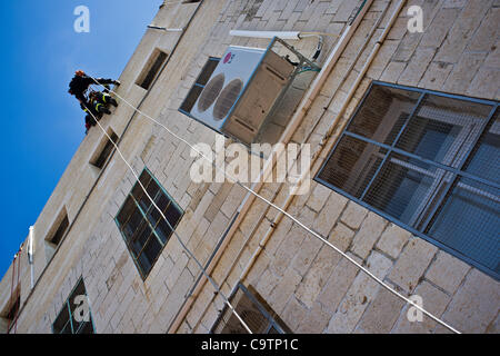 Feuerwehr Abseilen vom Dach der Schule bei den Rettungsarbeiten nach einem Erdbeben in einer landesweiten Übung Simulation an der Bet-Hakerem Grundschule. Jerusalem, Israel. 20. Februar 2012. Stockfoto