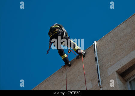 Feuerwehr Abseilen vom Dach der Schule bei den Rettungsarbeiten nach einem Erdbeben in einer landesweiten Übung Simulation an der Bet-Hakerem Grundschule. Jerusalem, Israel. 20. Februar 2012. Stockfoto