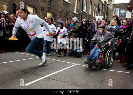 London. 21. Februar 2012. Ein behinderter Teilnehmer bei the Great Spitalfields Pancake Race am Faschingsdienstag, Fastnacht, an die Old Truman Brewery, London, UK. Dies ist ein lustiges schrulligen Jahresveranstaltung wo Konkurrenten als Teams von vier Personen kommen gekleidet im Kostüm einer Art. Organisiert durch Alternative Kunst Stockfoto