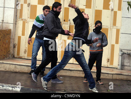 25. Februar 2012 - Hebron, Westjordanland - Palästinenser mit Steinen werfen auf israelische Soldaten während einer Demonstration Kennzeichnung 18 Jahre seit der "Höhle der Patriarchen Massaker." Im Jahr 1994 betrat US-amerikanischer jüdischer Siedler Baruch Goldstein den Raum in das Grab der Patriarchen, die dient als Moschee und sho Stockfoto