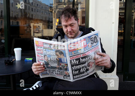 Ein Mann im Bild, lesen die neue Sonne am Sonntagszeitung vor einem Geschäft in Brighton, East Sussex, UK. Stockfoto