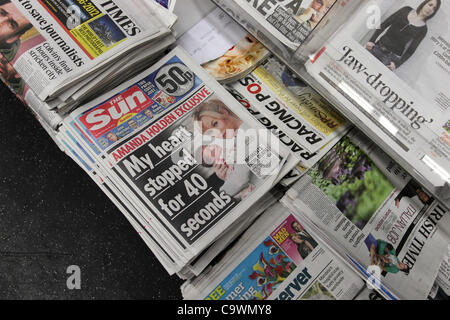 Ein Mann im Bild, lesen die neue Sonne am Sonntagszeitung vor einem Geschäft in Brighton, East Sussex, UK. Stockfoto