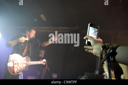 Frau nutzt das Iphone Video aus der ersten Startreihe am TheTyler Ward Gig im Speakeasy Queens University Belfast Studenten Union Sonntag, 26. Februar 2012 Stockfoto