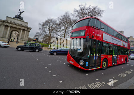 Der neue Hybrid Routemaster Bus verbindet schließlich die London eines der bestehenden Flotte von Hybrid-Doppeldecker Bus-Flotte auf Route 38 vorangestellt ist. Die Wellington Denkmal am Hyde Park Corner, London, UK - 27. Februar 2012. Stockfoto