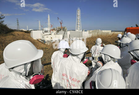 28. Februar 2012 - Okuma, Fukushima, Japan - Mitglied der Medien begleitet von TEPCO-Mitarbeiter, tragen Tyvex Schutzanzüge und Masken-Blick auf die Nummer 3 und Nummer 4 Reaktorgebäude der Tokyo Electric Power Co. (TEPCO) des Tsunami verkrüppelt Fukushima Daiichi Atomkraftwerk in Okuma, Fukushima Stockfoto