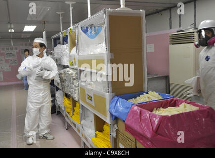 28. Februar 2012 - Okuma, Fukushima, Japan - bereitet ein Arbeiter Handschuhe im Notbetrieb Zentrum der Tokyo Electric Power Co. (TEPCO) des Tsunami verkrüppelt Fukushima Daiichi Atomkraftwerk in Okuma, Präfektur Fukushima, nordöstlich von Tokio, Japan, 28. Februar 2012. Mitglieder der Medien waren Stockfoto