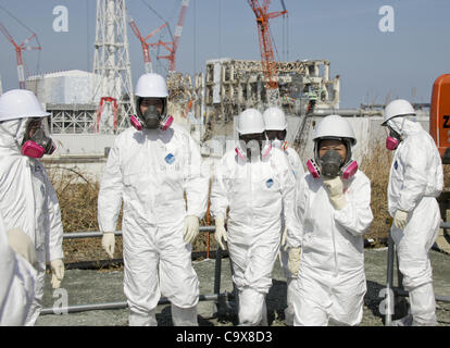 28. Februar 2012 - Okuma, Fukushima, Japan - Mitglied der Medien begleitet von TEPCO-Mitarbeiter, tragen Tyvex Schutzanzüge und Masken-Blick auf die Nummer 3 und Nummer 4 Reaktorgebäude der Tokyo Electric Power Co. (TEPCO) des Tsunami verkrüppelt Fukushima Daiichi Atomkraftwerk in Okuma, Fukushim Stockfoto