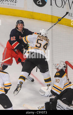 4. März 2012 Uhren - Newark, New Jersey, USA - New York Rangers linken Flügel Carl Hagelin (62) eine Erholung über das Ziel zu fliegen, wie er durch die Boston Bruins Verteidiger Adam McQuaid (54), während der ersten Periode NHL Aktion zwischen den New York Rangers und den Boston Bruins im Madison Square Garden in New aktiviert ist Stockfoto