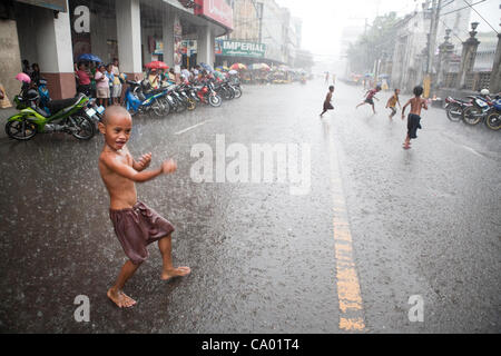 Cebu City, Philippinen, 11. März 2012: philippinische Kinder Spaß bei einem Regenguss während die Regenzeit zu Ende geht. Stockfoto