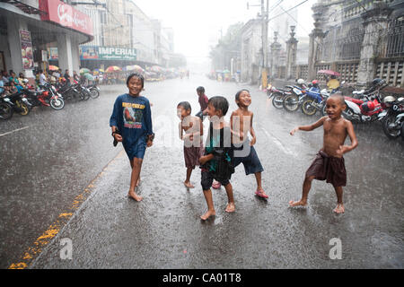 Cebu City, Philippinen, 11. März 2012: philippinische Kinder Spaß bei einem Regenguss während die Regenzeit zu Ende geht. Stockfoto