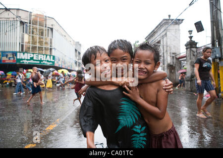 Cebu City, Philippinen, 11. März 2012: philippinische Kinder Spaß bei einem Regenguss während die Regenzeit zu Ende geht. Stockfoto