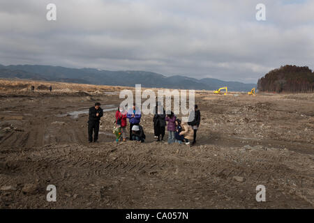 Eine Familie halten eine privaten Trauerfeier für Familienangehörige, die in dem Tsunami 2011 der schlammigen Ebene, wo einmal starb Stand ihrer Gemeinschaft von Kamaya, die 1 Jahr-Jubiläum der 11. März 2011 Erdbeben und Tsunami, in Kamaya, Region Tohoku, Japan Sonntag, 11. März 2012. Stockfoto