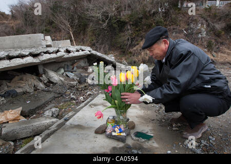 Takashi Sato (55 Jahre alt) legt Blumen am Haus seiner verstorbenen Schwester Toshiko, Region Tohoku, Japan am Sonntag, 11. März 2012 in dem Tsunami 2011 auf 1 Jahr-Jubiläum der 11. März 2011 Erdbeben und Tsunami in Minami Sanriku, gestorben. Stockfoto