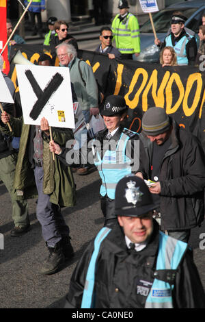 LONDON, UK, 14. März 2012 Verbindungsoffizier geht neben Demonstranten halten ein Plakat, das das Wort Occupy geschrieben. "The Protest Liaison Team wurde eingeführt, um Dialog & Verständnis zwischen Demonstranten und der Polizei zu verbessern", sagte der Metropolitan Police. Stockfoto