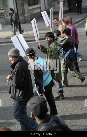 LONDON, UK, 14. März 2012 Verbindungsoffizier geht neben Demonstranten halten ein Plakat, das das Wort Occupy geschrieben. "The Protest Liaison Team wurde eingeführt, um Dialog & Verständnis zwischen Demonstranten und der Polizei zu verbessern", sagte der Metropolitan Police. Stockfoto