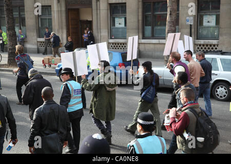 LONDON, UK, 14. März 2012 Verbindungsoffizier geht neben Demonstranten halten ein Plakat, das das Wort Occupy geschrieben. "The Protest Liaison Team wurde eingeführt, um Dialog & Verständnis zwischen Demonstranten und der Polizei zu verbessern", sagte der Metropolitan Police. Stockfoto