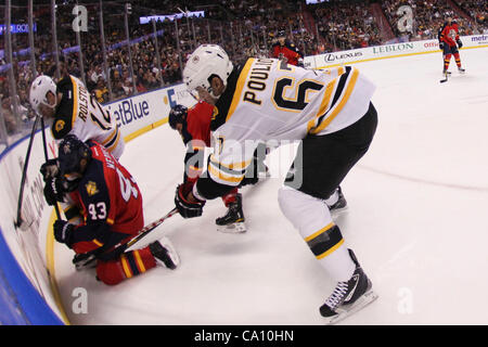 15. März 2012 - erfolgt Sunrise, Florida, Vereinigte Staaten von Amerika - Boston Bruins linken Flügel, was Benoit Pouliot (67) bei Florida Panthers Verteidiger Mike Weaver (43) mit dem Puck als Boston Bruins linken Flügel Brian Rolston (12 stößt) in der ersten Phase zwischen den Boston Bruins und die Florida Panthers bei Stockfoto