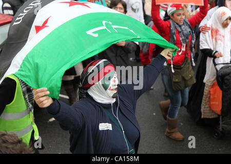 LONDON, UK, 17. März 2012. Ein Anti hält beim marschieren von Paddington Green an ihre Botschaft auf den Jahrestag des Aufstands zum protest gegen die herrschenden Assad-Regime und die aktuellen Themen in Syrien Assad Unterstützer der syrischen Flagge über dem Kopf. Stockfoto