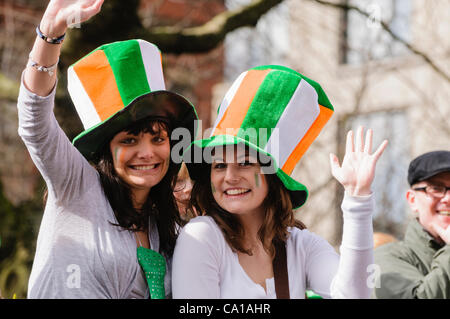 Belfast, UK. 17. März 2012. Junge Frauen mit irischen Trikolore Zylinder Lächeln und winken Stockfoto