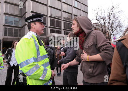 London, UK. 18. März 2012. Ein Polizist sprechen Sie mit einem der Mitglieder der Bewegung besetzen London. Die Gruppe hatte eine Überraschung März bis Parliament Square organisiert. Rund 40 Menschen marschierten dann auf der anderen Straßenseite auf Victoria Straße gefolgt von Polizei. Stockfoto