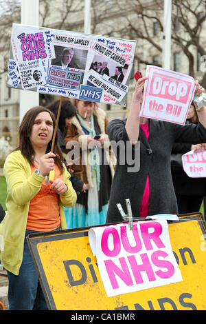 LONDON, VEREINIGTES KÖNIGREICH. 17. März 2012. Demonstranten halten Plakate und schreien Parolen gegenüber dem Parlament. Die Demonstranten versammelten sich in Parliament Square zum protest gegen die umstrittenen Gesundheit und soziale Betreuung Rechnung fällig zu kurz durchlaufen. Stockfoto