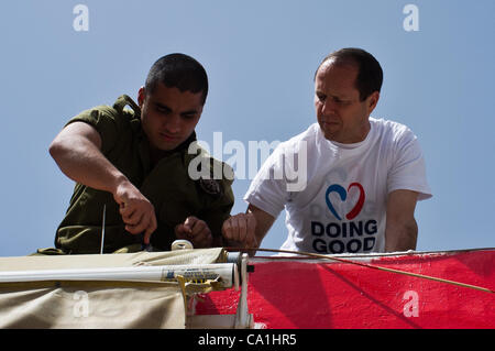 Bürgermeister Nir Barkat unterstützt einen freiwilligen IDF-Soldaten in der Malerei bei einem Besuch in einem der 48 Projekte durchgeführt, in der Stadt am "Tag der guten Taten", da die Gemeinde in ein nationales Projekt beteiligt ist, die Arbeit für die Gemeinschaft fördert. Jerusalem, Israel. 20. März 2012. Stockfoto