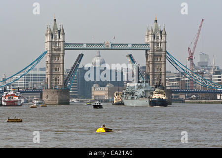 Basküle der Tower Bridge hob als Schlepptau HMS St Albans zerrt, als sie nach einem Besuch in der Stadt London verlässt. Stockfoto