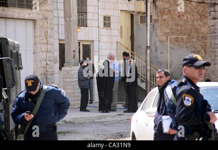 29. März 2012 - Hebron, Westjordanland, Palästinensische Autonomiegebiete - israelische Siedler Spaziergang vorbei an israelischen Grenzpolizisten Wachposten vor einem besetzten palästinensischen Haus nach Dutzenden von jüdischen Siedlern das Anwesen über Nacht übernahm, behaupten sie das rechtliche Eigentum, in der besetzten Westbank-Stadt der Stockfoto