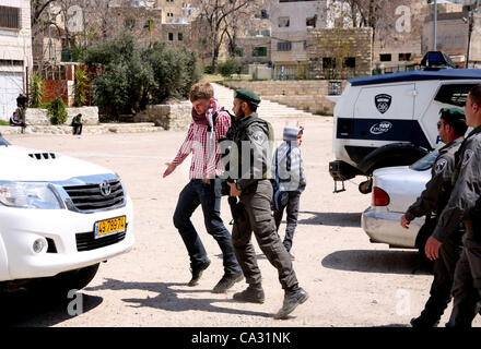 29. März 2012 - Hebron, Westjordanland, Palästinensische Autonomiegebiete - israelische Siedler Spaziergang vorbei an israelischen Grenzpolizisten Wachposten vor einem besetzten palästinensischen Haus nach Dutzenden von jüdischen Siedlern das Anwesen über Nacht übernahm, behaupten sie das rechtliche Eigentum, in der besetzten Westbank-Stadt der Stockfoto