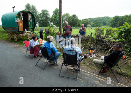 30. Mai 2012. Cumbria, UK. Mehrere Personen aus der Gemeinschaft Reisen sitzen um ein Lagerfeuer kochen Frühstück am Campingplatz in Kirkby Lonsdale. Des Reisenden sind für die Appleby Horse Fair fand im Juni statt Montage. Stockfoto