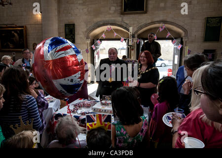 London, Vereinigtes Königreich, 06.02.2012. Der Bürgermeister von Camden, Heather Johnson und Vater David Houlding Schokolade Medaillen Kinder bei den indoor Straßenfest feiert die Königin Diamond Jubilee zu präsentieren. Die Party fand am All Hallows Church in Savernake Road, Gospel Oak statt. Stockfoto