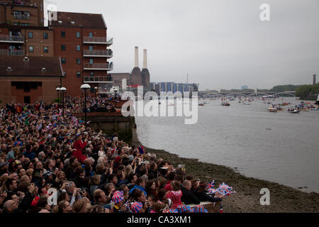 London, Vereinigtes Königreich. 2. Juni 2012 sammeln Massen an den Ufern der Themse, die nähernd Boote von Battersea Bridge zu sehen. Rund 1000 Boote gewebt ihren Weg durch die Mitte von London als Teil der Diamant-Jubiläum feiern. Stockfoto