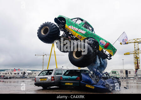 Monstertruck zerquetscht und springt über drei Autos auf der Extreme Stunt Show Stockfoto