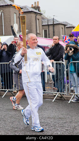 Freitag, 8. Juni 2012. North Ayrshire, Schottland, Vereinigtes Königreich. Thomas Tracey, 59, ein Charity-Marathon-Läufer aus Glasgow, trägt das Olympische Feuer durch das Dorf Barrmill in North Ayrshire, Schottland Stockfoto