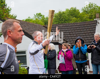 Freitag, 8. Juni 2012. North Ayrshire, Schottland, Vereinigtes Königreich. Thomas Tracey, 59, ein Charity-Marathon-Läufer aus Glasgow, trägt das Olympische Feuer durch das Dorf Barrmill in North Ayrshire, Schottland Stockfoto