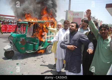 Ein Fahrer, seine Auto-Rikscha in Brand gesetzt, während einer Demonstration von allen Pakistan CNG Dealers Association am Tukhar Niaz Baig. Die Demonstranten kritisiert stark die mögliche Erhöhung der CNG-Tarife, während Parolen gegen die Regierung von ihnen bei der Gelegenheit in Lahore J skandierten waren Stockfoto