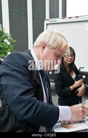 Montag, 11. Juni 2012. New York, USA. Boris Johnson, Bürgermeister von London UK hält, um sein Foto bei der Ankunft für Gastauftritt bei The Daily Show mit Jon Stewart zu unterzeichnen. Stockfoto