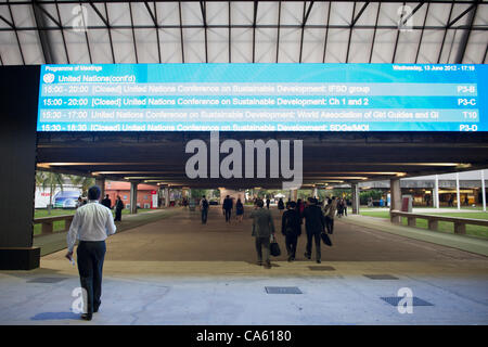 Ankunft in Rio Zentrum für die Konferenz die Menschen gehen unter einem elektronischen Zeichen geben das Tagungsprogramm für den Nachmittag. UN-Konferenz über nachhaltige Entwicklung (Rio + 20), Rio De Janeiro, Brasilien, 13. Juni 2012. Foto © Sue Cunningham. Stockfoto