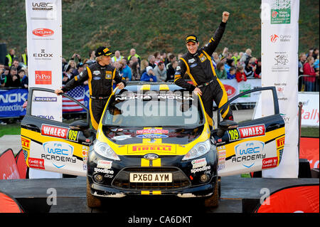 13.11.2011 Cardiff, Wales. Der neu gekrönte Gewinner der FIA WRC Academy Serie Craig Breen (IRL) und Co-Pilot Gareth Roberts (GBR) #109 Craig Breen Ford Fiesta R2 Stand auf dem Podium in der zeremoniellen beenden auf dem Gelände des Cardiff Castle im Laufe von Tag 4 der FIA WRC Wales Rallye GB. Stockfoto