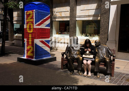 London 19.06.12. Eine Frau Texte mit Statuen von F.D Roosevelt & Winston Churchill auf einer Bank in Bond Street nr der "Union Jack 2012" Replikat Artbox Telefon Kiosk von Sir Peter Blake (Künstler der Beatles "Sgt. Pepper") und Teil eines Kunstprojektes für die Queen Diamond Jubilee und Olympischen Spielen. Stockfoto