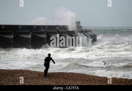 Riesige Wellen über Brighton Marina Hafen Arm heute als Frau Spaziergänge am Strand Stockfoto